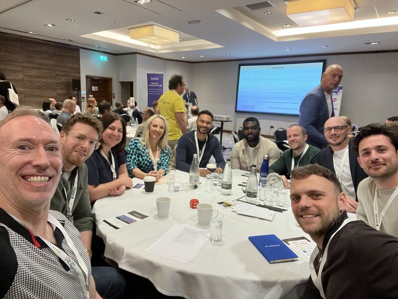 Selfie taken by Chris Gibbins during his roundtable talk at Experimentation Elite, featuring attendees gathered around the discussion table.