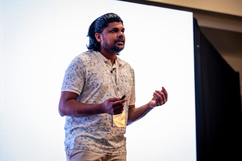 Vignesh Lokanathan delivering his talk on stage at experimentation elite