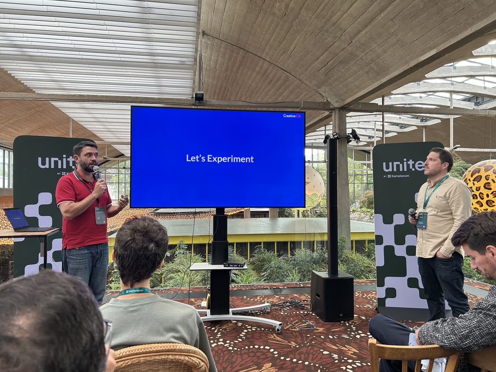 Mark Pybus and Alexandre Chomienne presenting a live problem-first experimentation session at Unite Paris, with a “Let’s Experiment” slide.